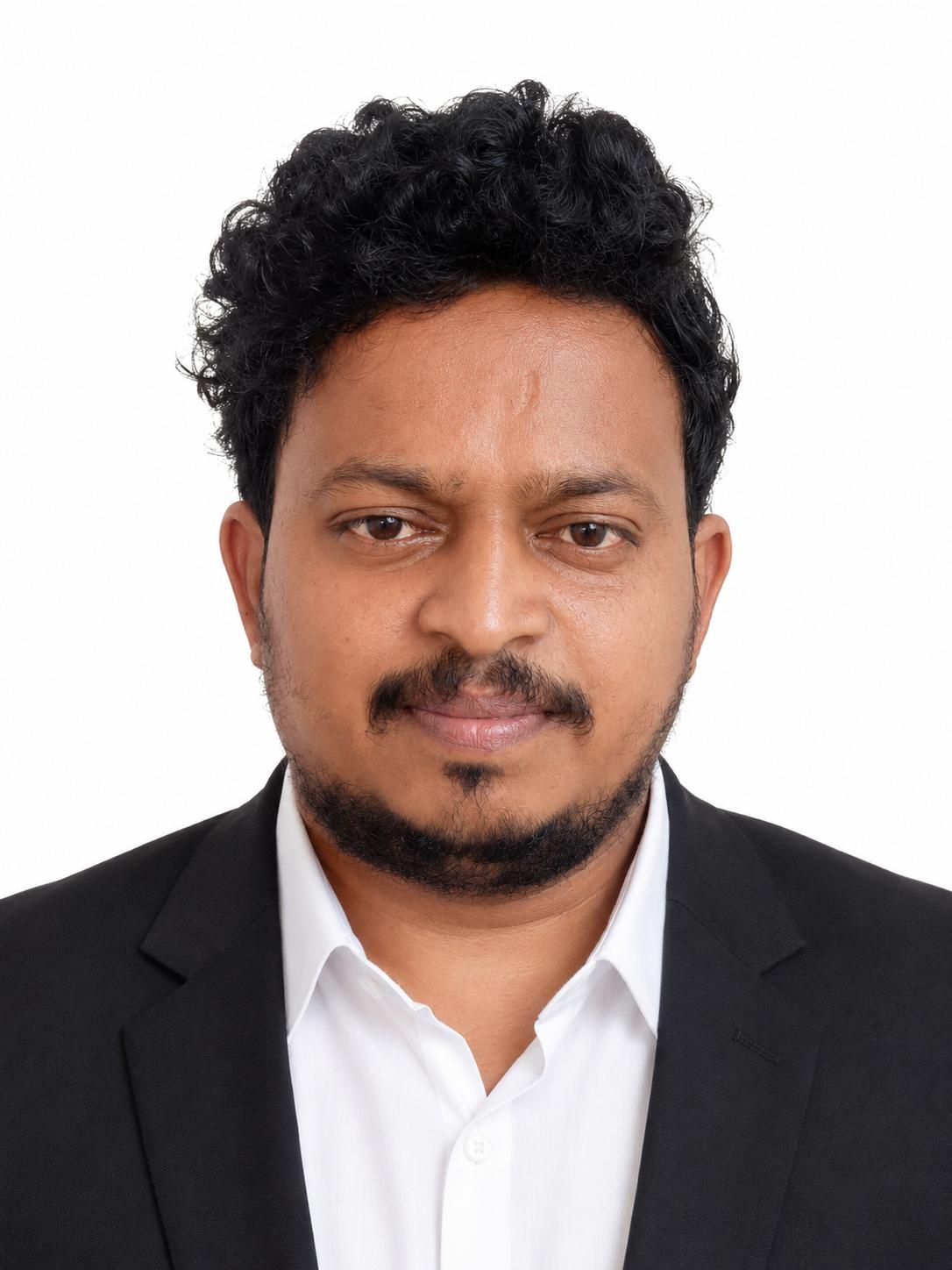 Dinesh Uyyala wearing a black suit and white shirt